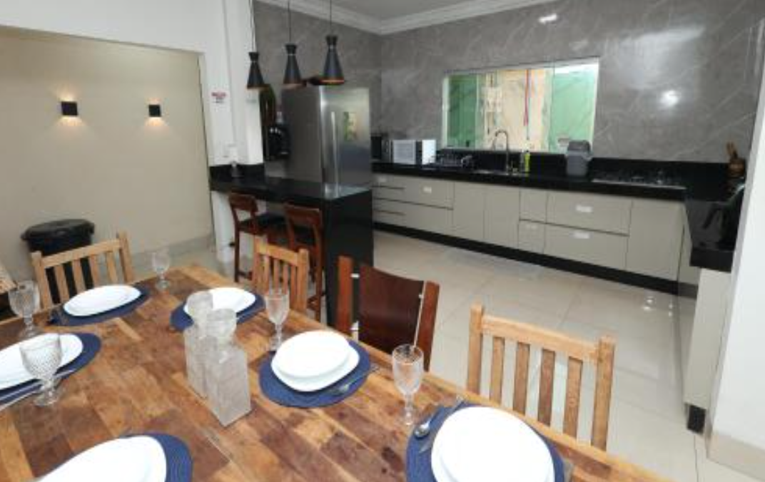 Cozinha ampla e equipada com mesa de refeições